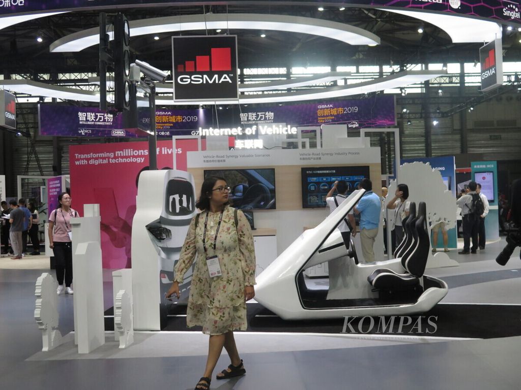 Pengunjung melintas di sisi mobil yang didukung dengan menggunakan teknologi 5G di arena MWC 2019 Shanghai, China, Kamis (27/6/2019).