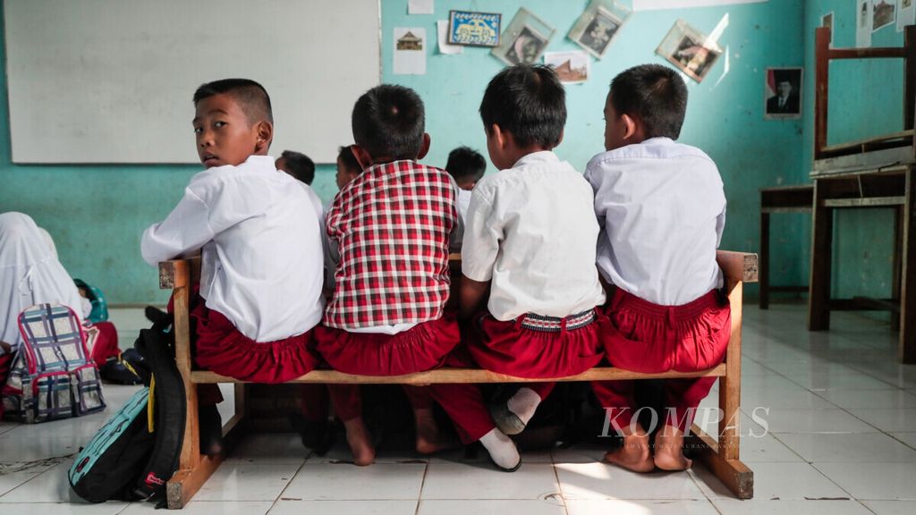 Siswa kelas IV SD Negeri Tegal 4, Kemang, Kabupaten Bogor, Jabar, belajar dengan kondisi kekurangan bangku dan kursi, Senin (29/7/2019). 