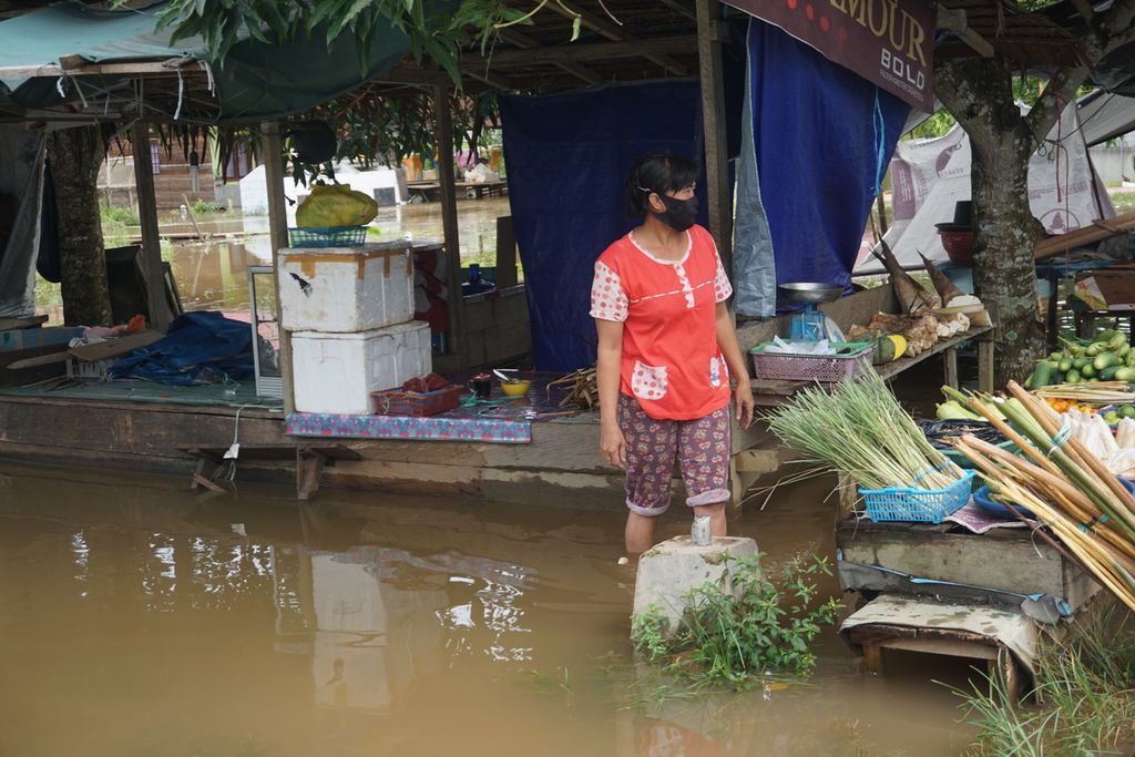 Salah satu pedagang di Pasar Kasongan, Kabupaten Katingan, Kalimantan Tengah, masih tetap berjualan di tengah banjir akibat luapan Sungai Katingan. Di wilayah itu, seluruh kecamatan terendam banjir, Rabu (8/9/2021).