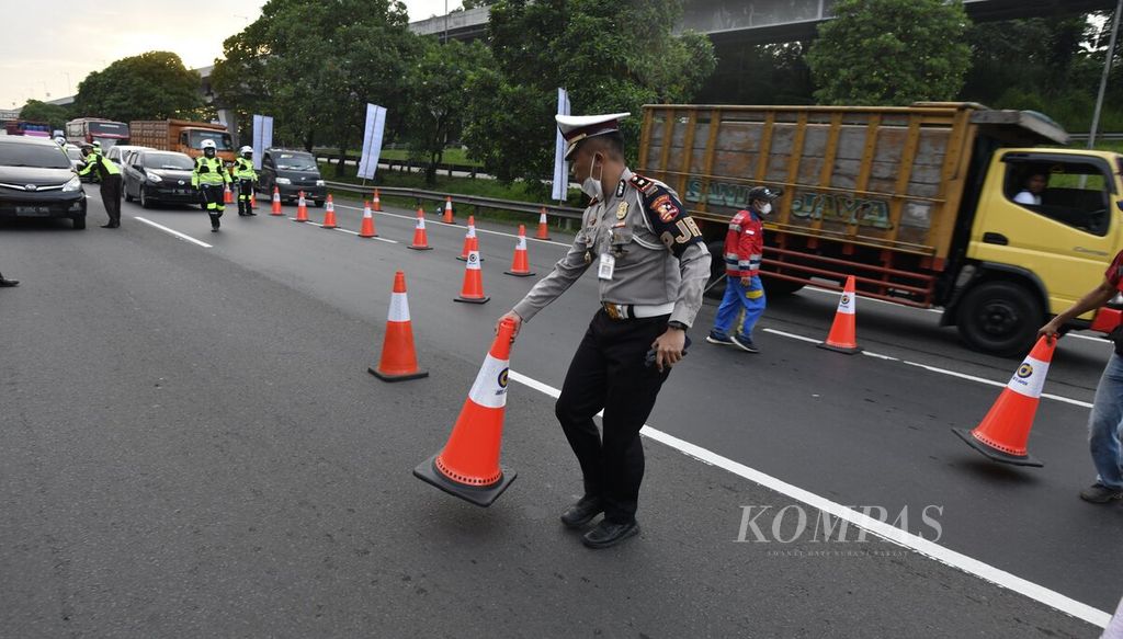 Petugas mengatur rambu kerucut saat rekayasa lalu lintas satu arah (<i>one way</i>) mulai diberlakukan di Kilometer 47 Jalan Tol Jakarta-Cikampek di Karawang, Jawa Barat, Kamis (29/4/2022) pukul 17.30 WIB.