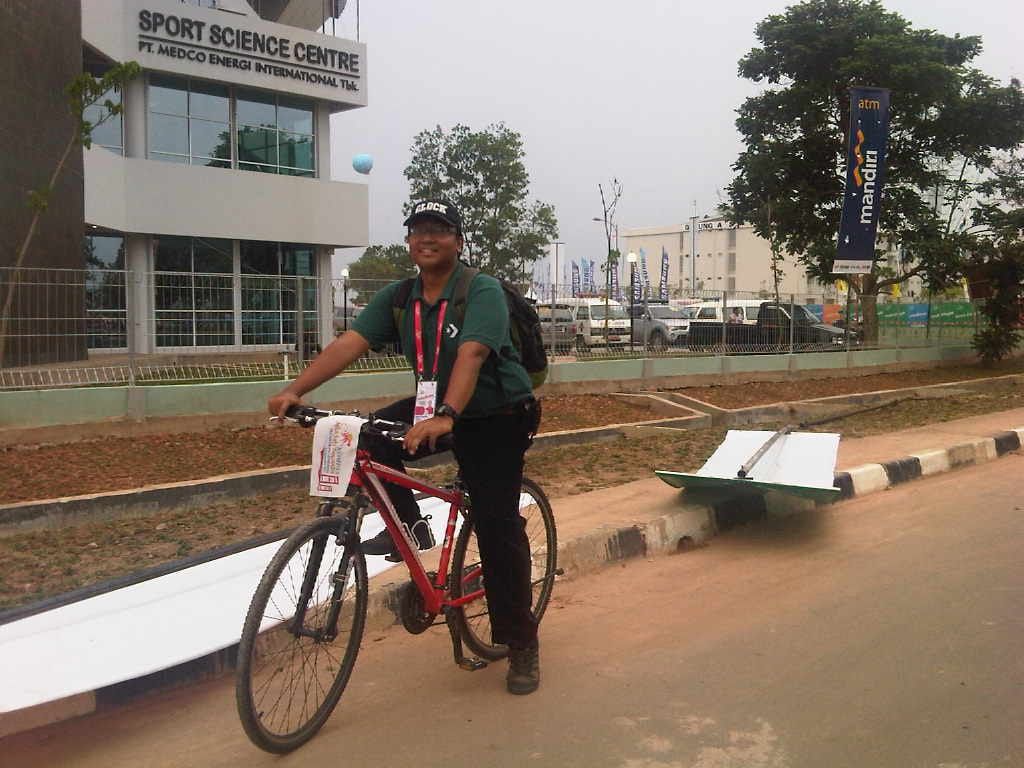 Wartawan harian <i>Kompas </i>Wisnu Aji Dewabrata mengendarai sepeda merah di arena liputan SEA Games 2011 di Palembang. Sepeda itu kemudian hilang dicuri.