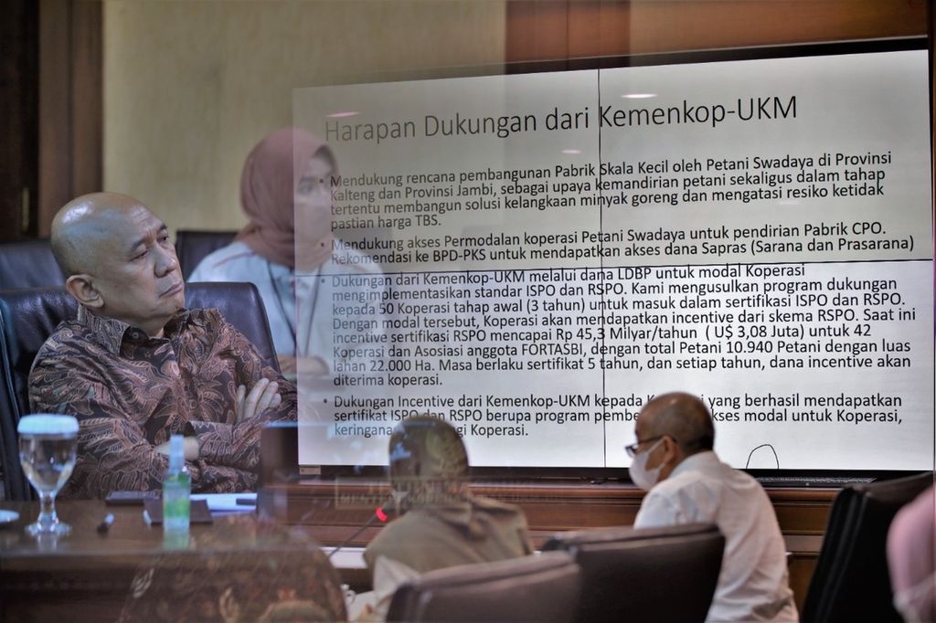 Menteri Koperasi dan UKM Teten Masduki (kiri) mendengarkan presentasi rencana pendirian pabrik minyak makan sawit merah yang dilakukan sejumlah petani kelapa sawit di Kementerian Koperasi dan UKM, Jakarta, Selasa (24/5/2022). 
