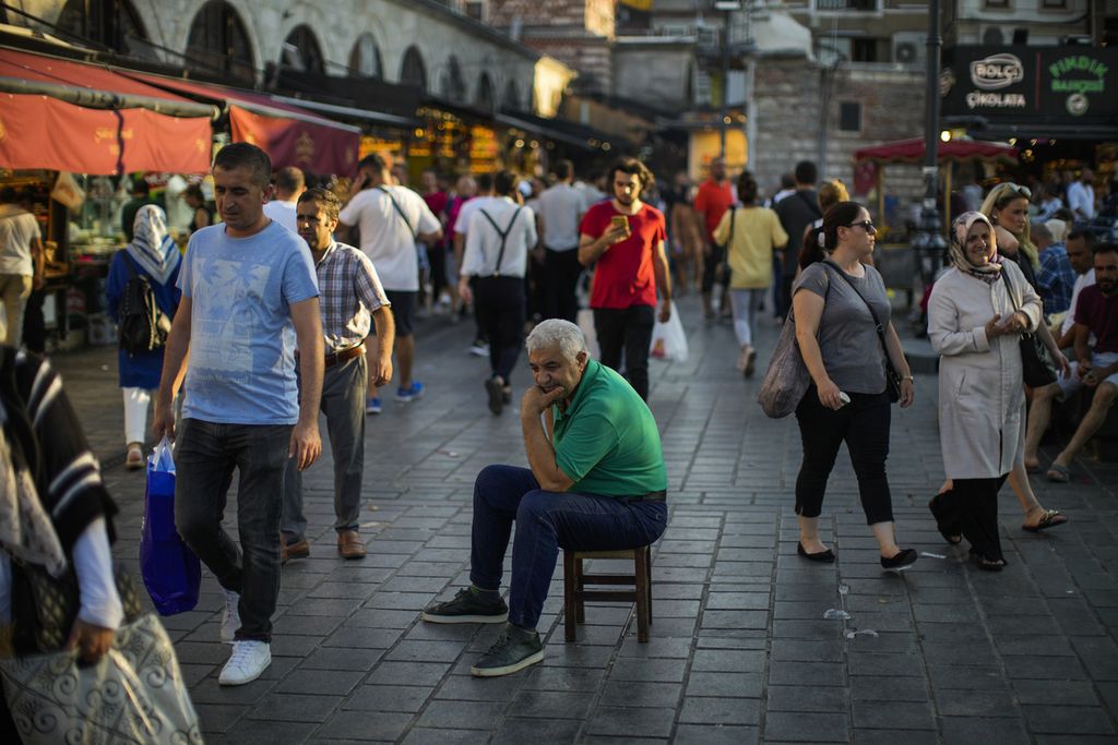 Seorang pria duduk di jalur pejalan kaki di pasar rempah-rempah di Istanbul, Turki pada Kamis (18/8/2022).