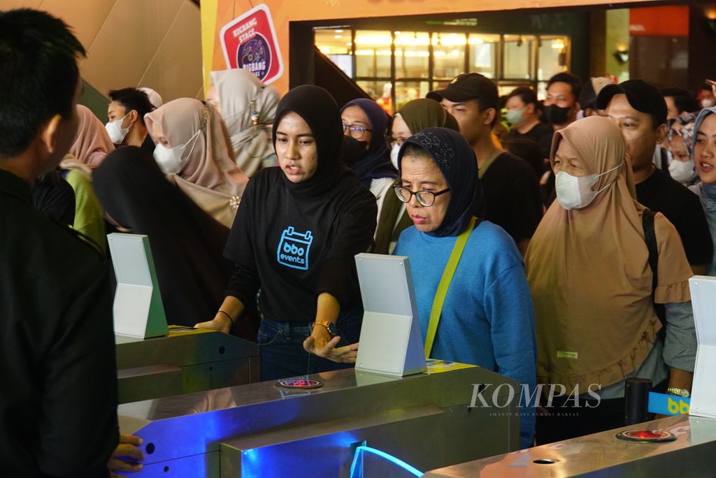 Petugas tiket membantu seorang pengunjung untuk masuk ke gelaran cuci gudang Big Bang Festival 2023 di JIExpo Kemayoran, Jakarta, Kamis (28/12/2023). 
