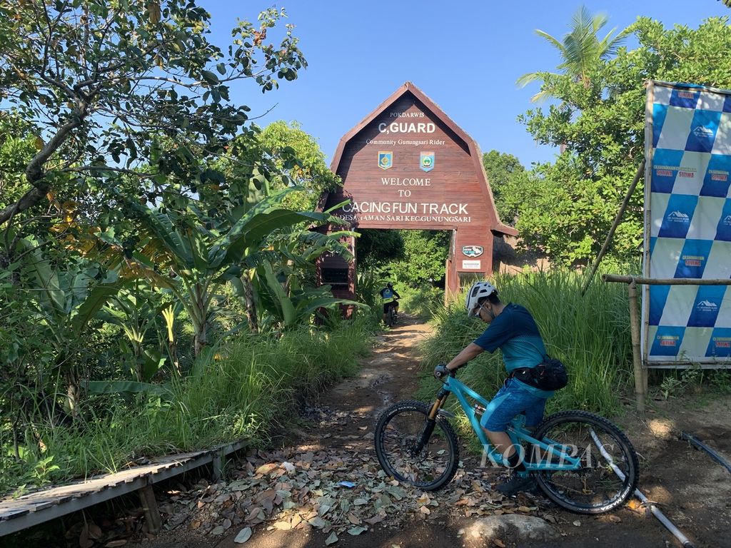 Seorang pesepeda gunung mengayuh sepedanya memasuki gerbang Cacing Fun Track di kawasan Bukit Cacing di Desa Taman Sari, Kecamatan Gunung Sari, Lombok Barat, Nusa Tenggara Barat, Sabtu (13/5/2023).