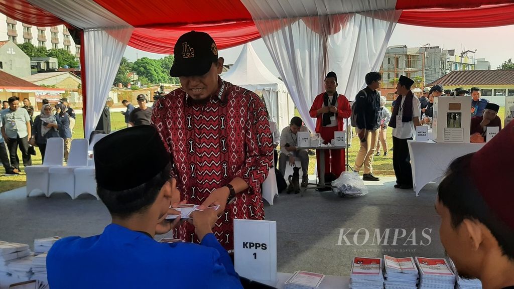 Warga menerima kertas surat suara dari petugas KPPS saat simulasi pemungutan dan penghitungan suara pilkada serentak 2024 digelar di Lapangan Sepak Bola Kukusan, Depok, Jawa Barat, Sabtu (7/9/2024).