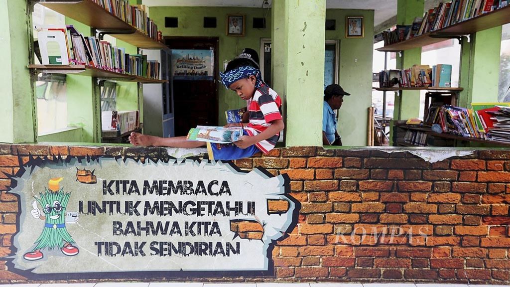 Anak-anak membaca koleksi buku di Taman Baca Kolong Jembatan Layang Ciputat, Tangerang Selatan, Banten, Senin (7/5/2018). Membaca di usia dini dapat mengoptimalkan kemampuan anak dalam berbahasa dan berkomunikasi.