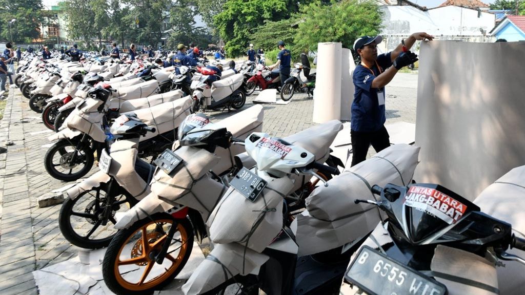 Pekerja menyiapkan sepeda motor warga yang mengikuti angkutan mudik gratis sepeda motor di Stasiun Jakarta Gudang, Jakarta, Minggu (26/5/2019), Mudik gratis sepeda motor menjadi salah satu upaya pemerintah untuk mengurangi menggunakan sepeda motor saat mudik.