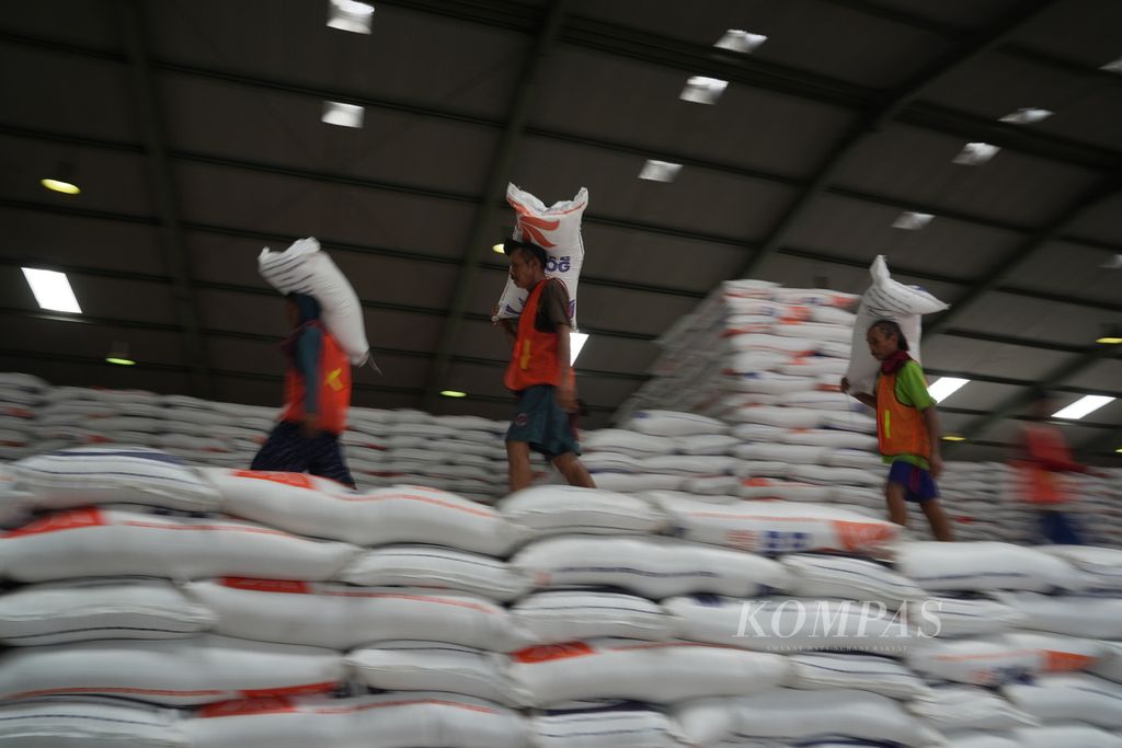 Pekerja mengangkut karung beras di kawasan pergudangan modern Perum Bulog, Sunter Timur, Kelapa Gading, Jakarta Utara, Sabtu (30/12/2023). Perum Bulog mendatangkan teknologi mesin <i>rice to rice</i> (RtR) untuk memastikan ketersediaan, kualitas, dan mutu berasnya semakin baik. Stok beras yang dikuasai Perum Bulog saat ini sebanyak 1,15 juta ton dan ditambah dengan stok beras impor dalam perjalanan sehingga jumlahnya sangat aman dan mampu menjaga stabilitas harga pada tahun 2024. 