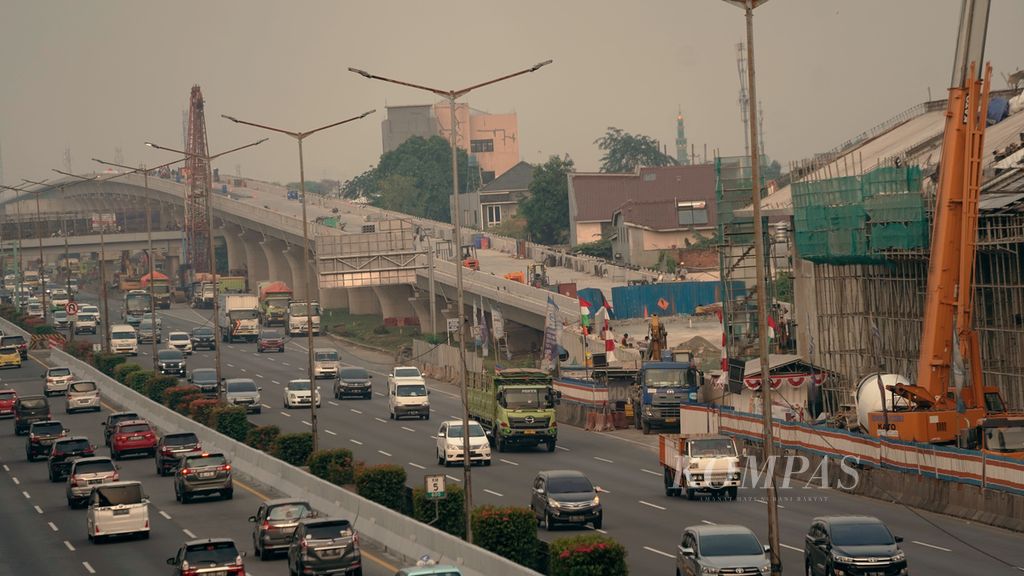 Kendaraan melintasi Jalan Tol Cikampek di samping proyek lintasan menurun Kereta Cepat Jakarta-Bandung di Kelurahan Jaticempaka, Kecamatan Pondokgede, Kota Bekasi, Jawa Barat, Selasa (2/8/2022). Biaya proyek Kereta Jakarta-Bandung membengkak menjadi Rp 114,24 triliun dari rencana awal Rp 86,5 triliun. Selain biaya membengkak, proyek yang seharusnya selesai tahun 2019 molor menjadi 2023. 