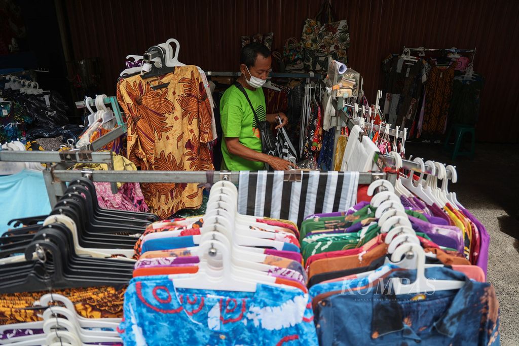 Subardi (63) menata baju yang ia jual di trotoar Jalan Malioboro, Yogyakarta, untuk terakhir kali, Senin (31/1/2022). 