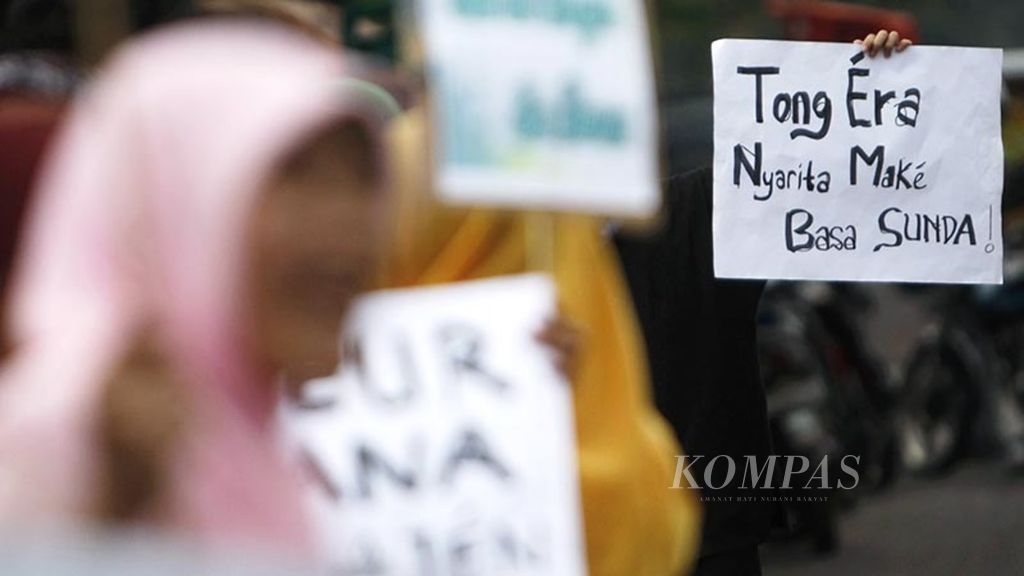 Mahasiswa Universitas Pendidikan Indonesia (UPI) Bandung menggelar aksi dengan membawa poster yang berarti "Jangan Malu Berbicara Menggunakan Bahasa Sunda" saat Peringatan Hari Bahasa Ibu, di tepi Jalan Diponegoro, Bandung, Jawa Barat, Selasa (21/2/2012). 