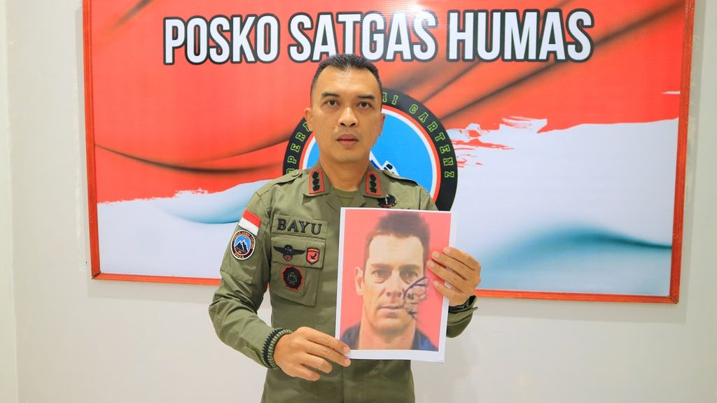 Kepala Satuan Tugas Humas Operasi Damai Cartenz Komisaris Besar Bayu Suseno membawa foto pilot asal Selandia Baru, Glen Malcolm Conning, di Kabupaten Mimika, Papua Tengah, Senin (5/8/2024).