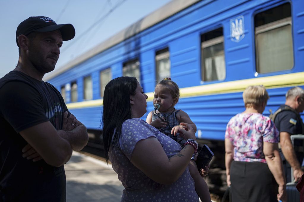 Keluarga pengungsi antre masuk kereta api di Pokrovsk, Donetsk, Ukraina, Senin (19/8/2024).