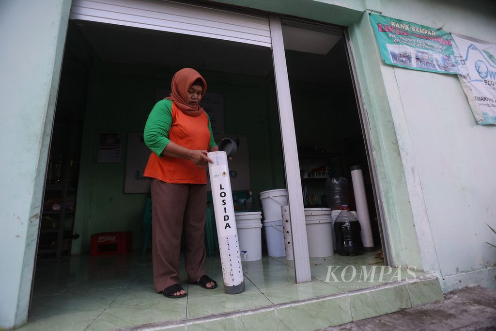Ketua Bank Sampah Lintas Winongo Siti Rojanah memeriksa sampah di dalam alat Losida (Lodong sisa dapur) di Kampung Badran RW 011, Kelurahan Bumijo, Jetis, Yogyakarta, Jumat (22/9/2023). 