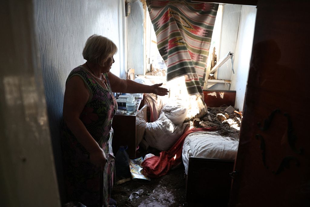 Seorang perempuan yang sudah lanjut usia memperlihatkan kerusakan bagian rumah kediamannya akibat serangan udara militer Rusia di Kota Bakhmut, wilayah Donetsk, Sabtu (16/7/2022).