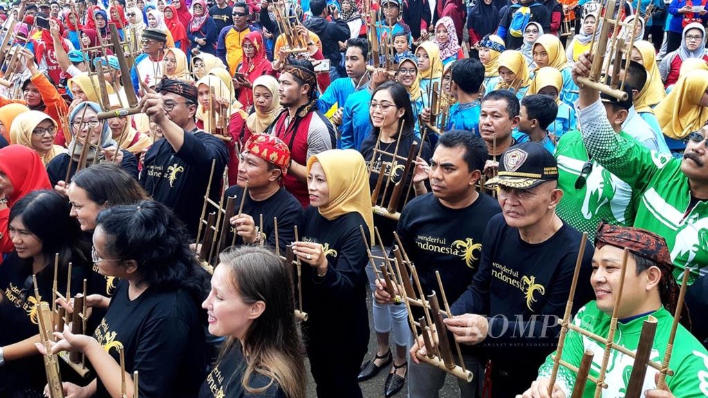 Peserta memainkan angklung dalam Festival Angklung Internasional di Waduk Darma, Kabupaten Kuningan, Jawa Barat, Minggu (28/4/2019). Festival yang digelar untuk ketiga kalinya itu diikuti 270 peserta dari 40 sekolah tingkat dasar hingga menengah di Kuningan.