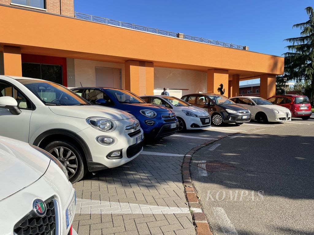 Mobil-mobil biasa" parkir di depan toko pernak-pernik ofisial Ferrari di Kota Maranello, Italia pada Jumat (9/9/2022). karena harga dan eksklusifitasnya, merek Ferrari tak lantas mendominasi jalanan perkotaan, termasuk di kota kelahirannya sendiri.