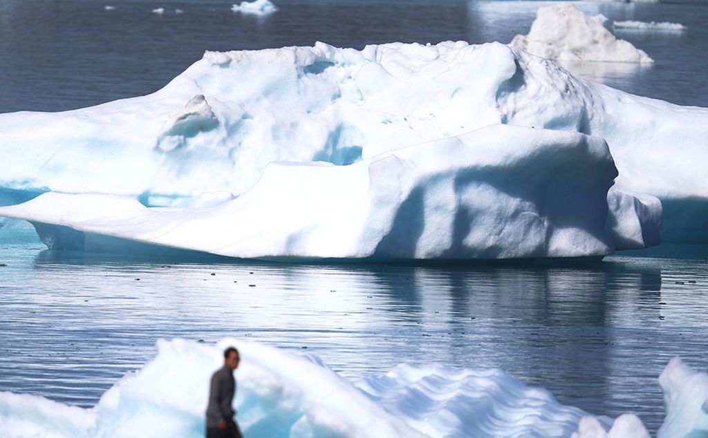 Gunung es terlihat mengambang pada 30 Juli 2013 di Narsaq, Greenland. Ketika kota-kota seperti Miami, New York, dan tempat-tempat rentan lainnya di seluruh dunia menyusun strategi cara merespons perubahan iklim, banyak penduduk Greenland melakukan apa yang selalu mereka lakukan: beradaptasi.