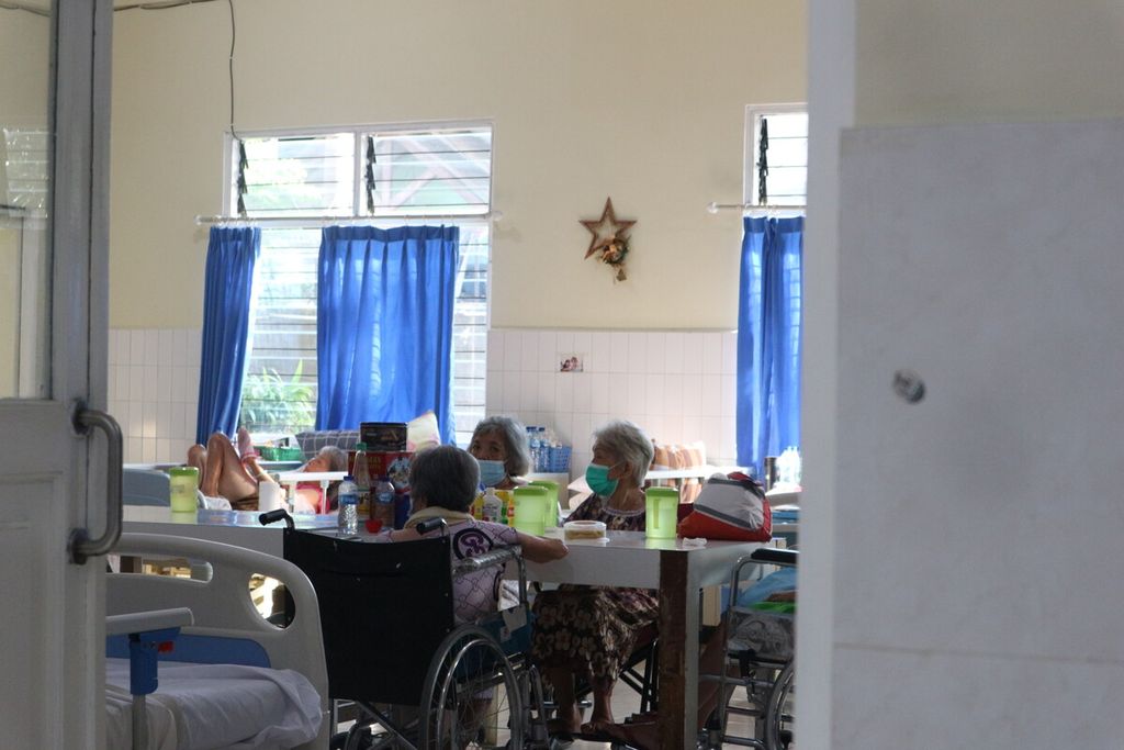 Para penghuni Wisma Sahabat Baru berkumpul dan bercengkerama di meja makan yang terletak di tengah ruangan hunian mereka, di Kebon Jeruk, Jakarta Barat, Selasa (20/12/2022). Pada 25 Desember 2022, di ruangan ini akan diadakan ibadah dan kebaktian untuk merayakan Natal. 