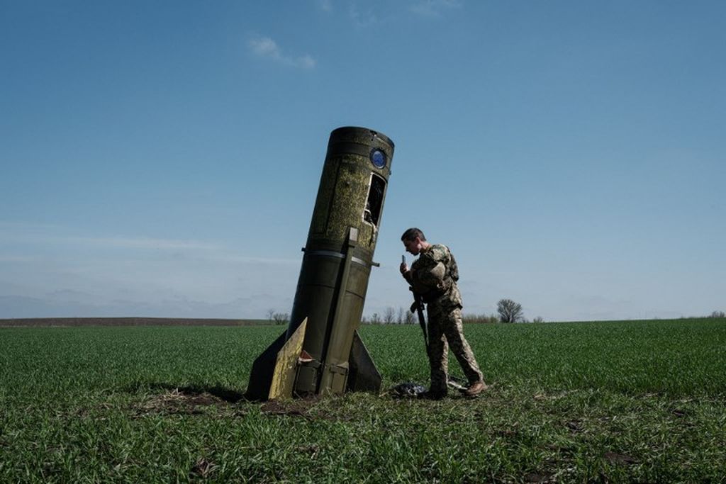 Seorang prajurit Ukraina melihat bagian rudal balistik Rusia yang menghantam sebuah tanah lapang di Bohodarove, Ukraina timur, Senin, 25 April 2022, di tengah perang Rusia di Ukraina. 