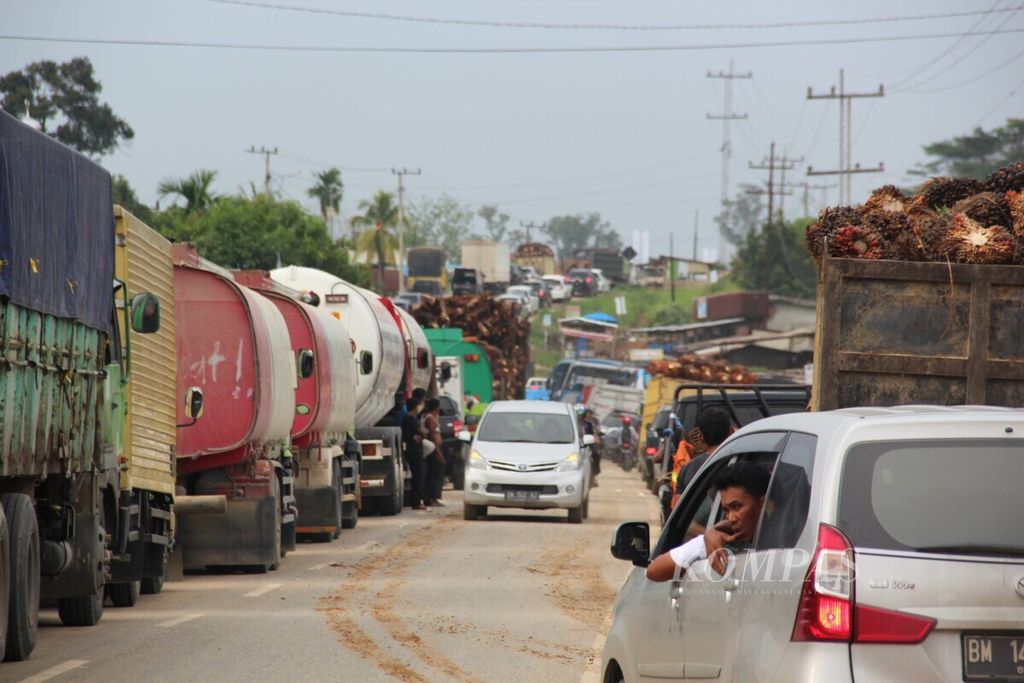 Ribuan truk pengangkut kayu atau minyak sawit mentah (CPO) dengan muatan berlebih melintas di jalan setiap hari sehingga membuat jalan raya di Riau mudah rusak.