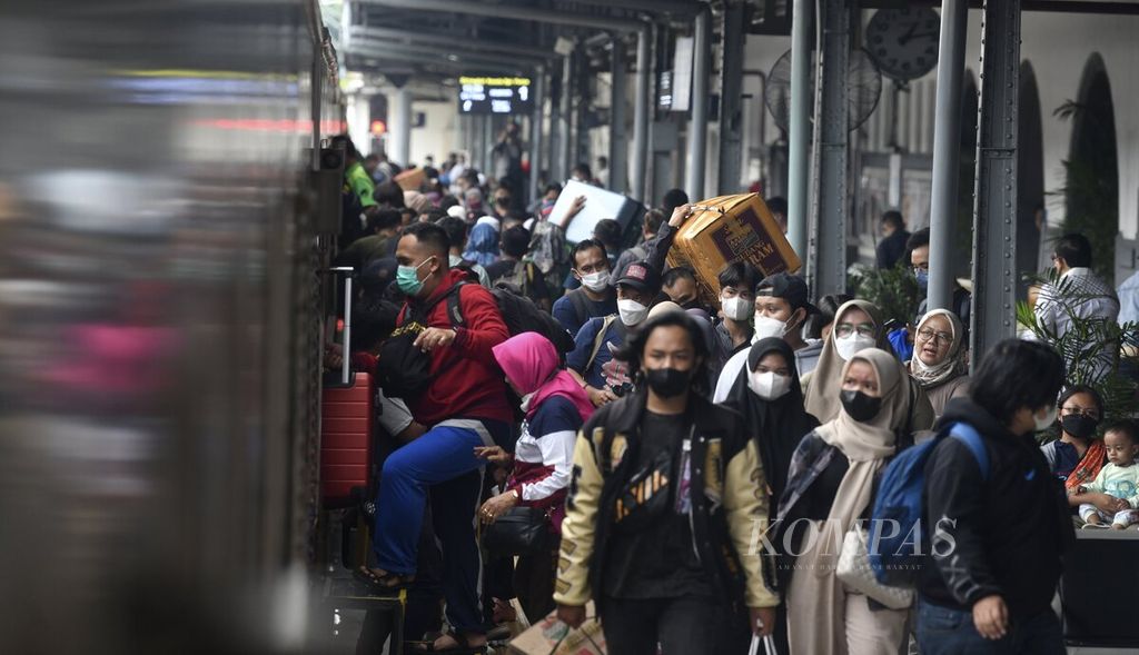 Penumpang kereta api bersiap masuk ke gerbong kereta saat KA Brantas dengan tujuan Blitar telah tersedia di Stasiun Pasar Senen, Jakarta, Kamis (22/12/2022).