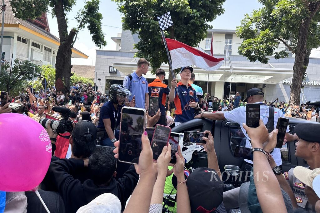 Ribuan warga Kota Mataram dan sekitarnya berdesak-desakan untuk bisa mengambil foto saat parade pebalap di kawasan Jalan Pejanggik, Kota Mataram, Nusa Tenggara Barat, Rabu (11/10/2023) siang. Parade yang diikuti sejumlah pebalap Moto2 dan Moto3 itu diselenggarakan sebagai salah satu rangkaian MotoGP seri Indonesia yang akan berlangsung di Sirkuit Internasional Pertamina Mandalika, 13-15 Oktober 2023.