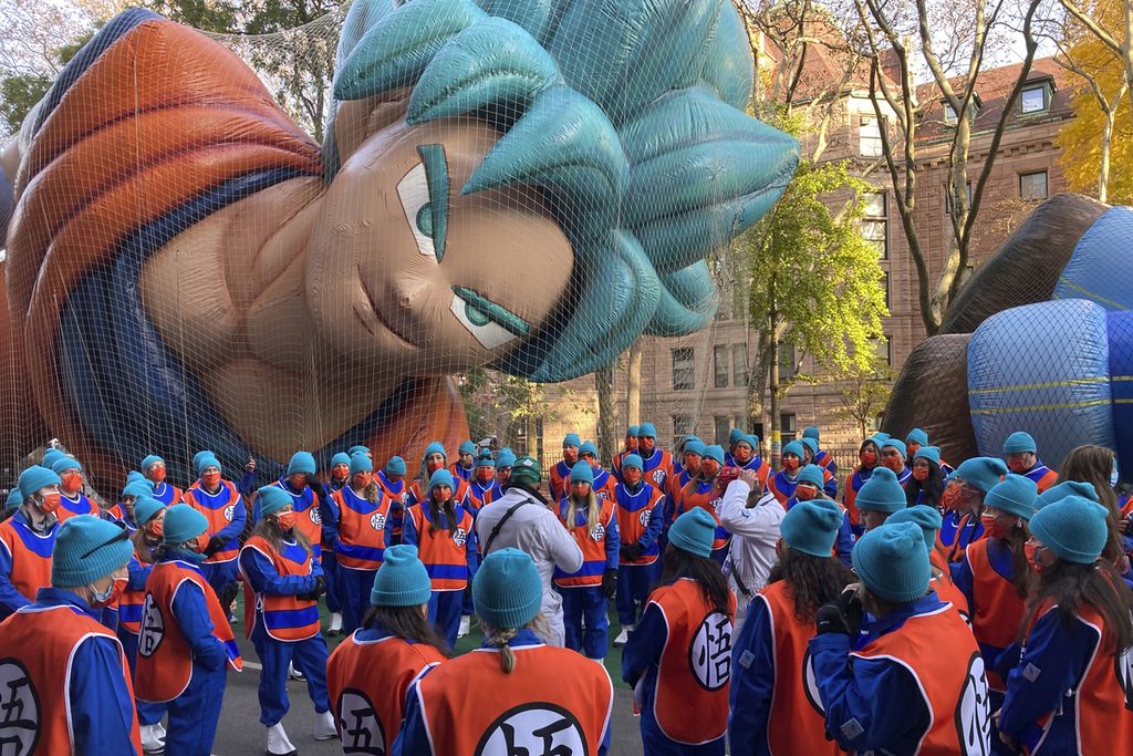 Orang-orang membantu menegakkan balon helium yang menggambarkan sosok tokoh serial manga <i>Dragon Ball</i>, Son Goku, saat parade Thanksgiving di New York, Amerika Serikat, 21 November 2021. 