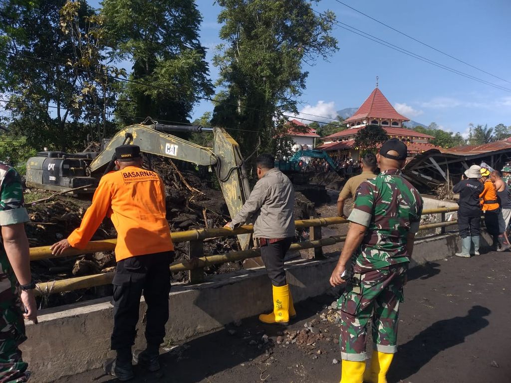 Petugas gabungan menyaksikan proses pembersihan sungai dengan alat berat setelah banjir lahar hujan dari Gunung Marapi di Nagari Bukik Batabuah, Kecamatan Canduang, Kabupaten Agam, Sumatera Barat, Sabtu (6/4/2024).