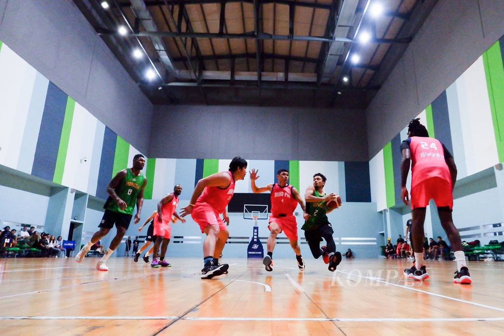 <i>Guard</i> timnas basket Yudha Saputera (memegang bola) beraksi dalam uji coba dengan versus Rans PIK di GBK Arena, Jakarta, Jumat (28/4/2023). 