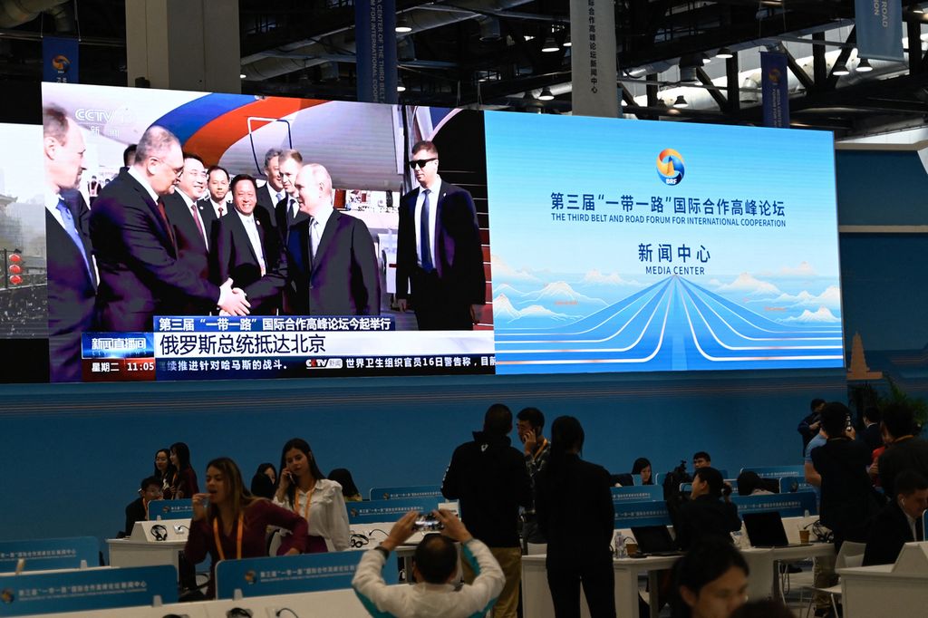 Sebuah layar di pusat media Forum Belt and Road ketiga menunjukkan liputan berita tentang kedatangan Presiden Rusia Vladimir Putin di Bandara Internasional Beijing, Selasa (17/10/2023). 