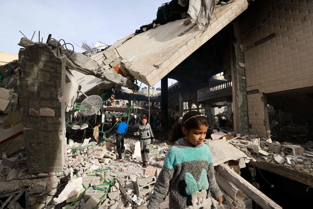 Warga Gaza di antara puing akibat pengeboman Israel di Rafah pada Senin (12/2/2024).