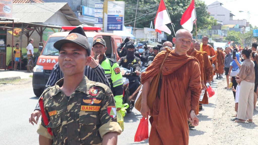 Anggota Banser ikut menjaga saat 32 biksu menyusuri jalan raya di Kecamatan Jatibarang, Kabupaten Indramayu, Jawa Barat, Selasa (17/5/2023). 