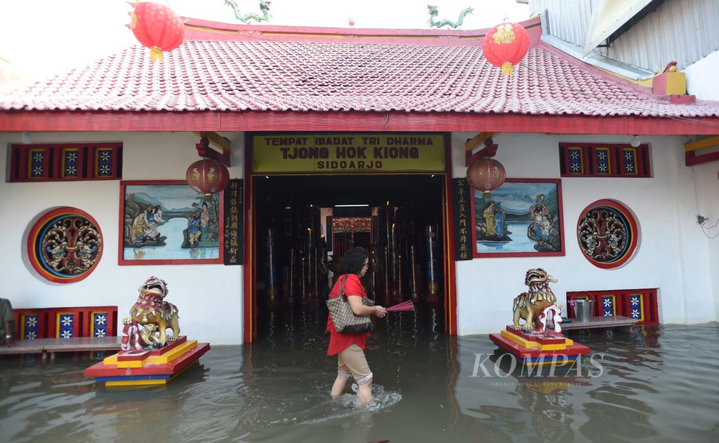 Warga keturunan Tionghoa sembahyang hari raya Imlek di tengah banjir di Tempat Ibadat Tri Dharma Tjong Hok Kiong di Sidoarjo, Jawa Timur, Senin (8/2). Warga yang bersembahyang berharap di tahun yang baru akan dilimpahkan rezeki.