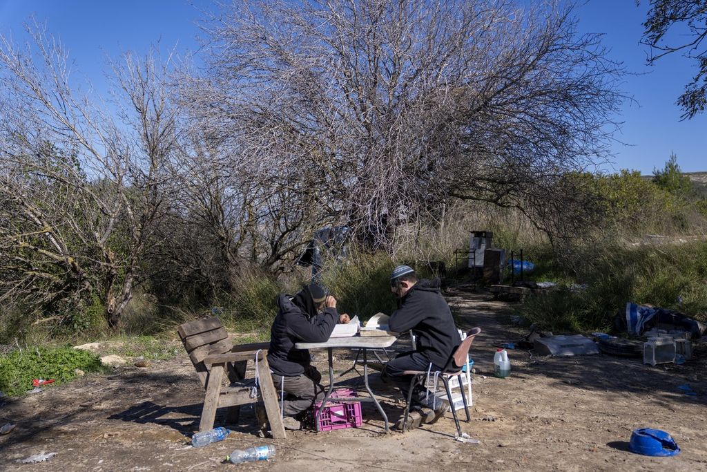 Dua warga Yahudi duduk di sebuah lokasi di Homesh, Minggu (17/5/2022), wilayah yang digadang-gadang akan kembali dibangun permukiman dan tempat belajar kitab tradisional kaum Yahudi. Mulai 20 Mei 2023, pemerintahan sayap kanan Israel mencoba membalikkan situasi itu dengan mengizinkan warganya datang ke Homesh.