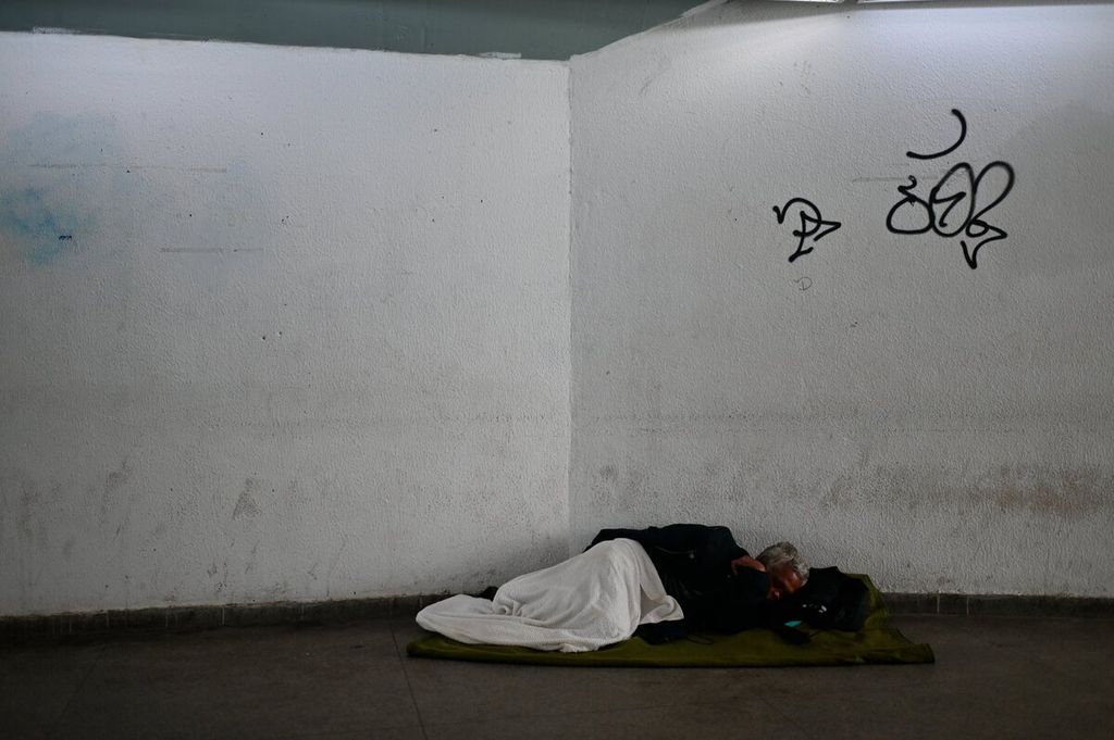 Seorang pria tunawisma tidur di dalam Terminal Bus BRT Recreio di Rio de Janeiro, Brasil, Kamis (28/10/2021). Bank Dunia memperkirakan kemiskinan di Brasil akan meningkat menjadi 15,7 persen pada tahun 2021 karena masyarakat miskin dan rentan telah terkena dampak yang besar oleh pandemi Covid-19. 