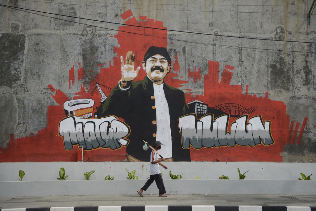 Pejalan kaki melintas di depan mural bergambar sosok Wali Kota Surakarta FX Hadi Rudyatmo di Jalan Ir Juanda, Surakarta, Jawa Tengah, Sabtu (13/2/2021).  