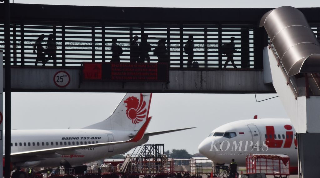 Penumpang berjalan melewati garbarata saat akan memasuki pesawat di Terminal 2 Bandara Internasional Soekarno-Hatta, Tangerang, Banten, Senin (8/4/2024). 