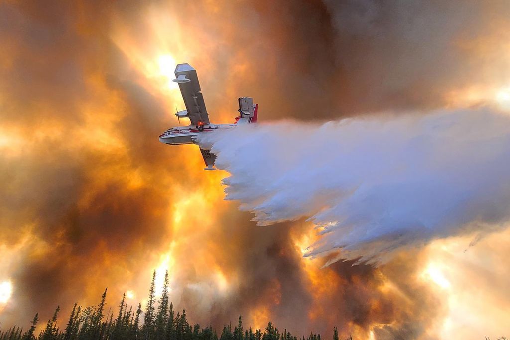 Pesawat menyiramkan air di titik api dekat Anderson, Alaska, Amerika Serikat, 6 Juli 2022. 