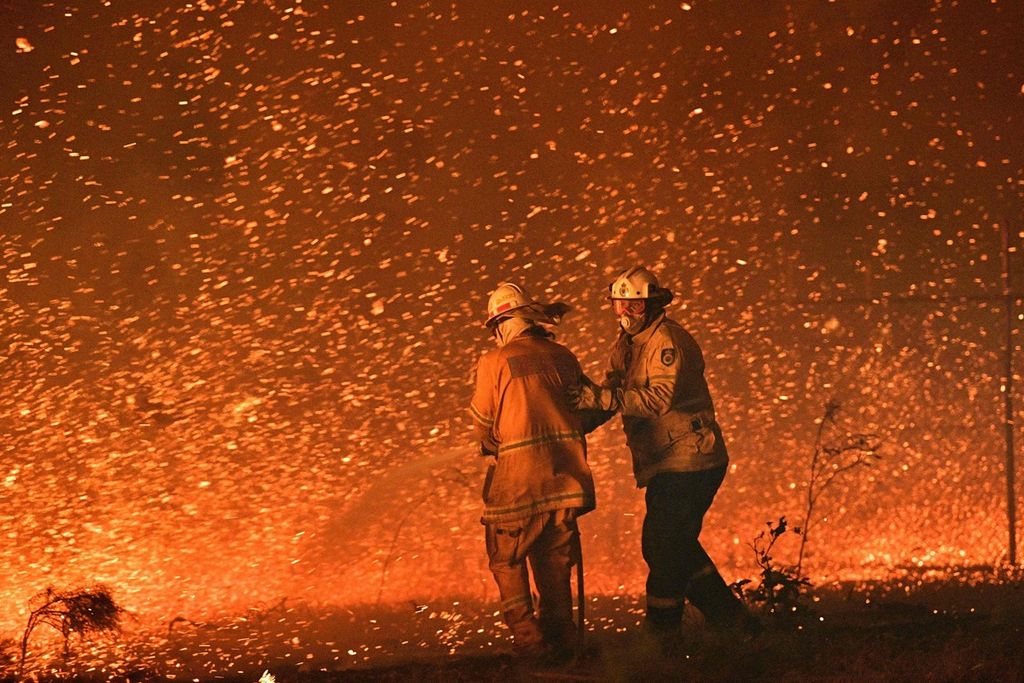Foto yang diambil pada 31 Desember 2019 tampak pemadam kebakaran tengah berupaya memadamkan api yang melahap semak belukar di Nowra, Negara Bagian New South Wales.