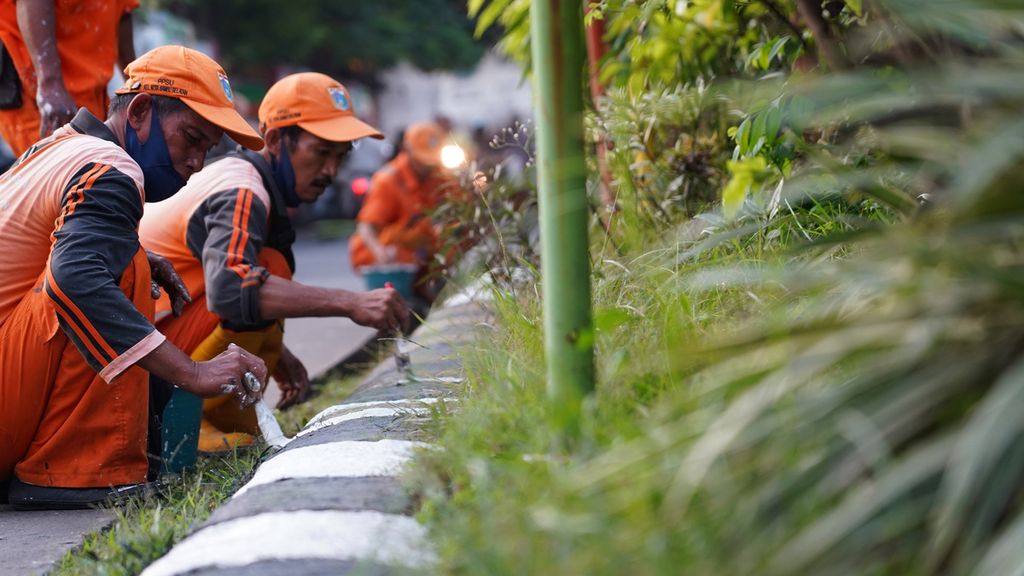 Petugas Penanganan Prasarana dan Sarana Umum (PPSU) Kelurahan Kota Bambu Selatan mengecat pembatas ruas jalan di sekitar Jalan Taman Bunga 1, RW 001 Kota Bambu Selatan, Jakarta Pusat, Senin (20/6/2022). Kegiatan mengecat pembatas tepi jalan ini dalam rangka menyambut HUT ke-495 Jakarta. Selain melakukan pengecatan, mereka juga merapikan lingkungan setempat agar tetap bersih dalam menyambut ulang tahun ibukota ini.