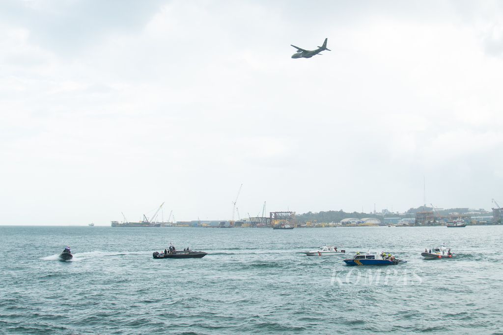 Pesawat TNI Angkatan Udara, CN-235, melintas saat petugas gabungan dari TNI Angkatan Laut, Polisi Air, Badan Keamanan Laut, Bea dan Cukai, Kesatuan Penjagaan Laut, serta Imigrasi menggelar simulasi penyergapan perahu penyelundup pekerja migran di perairan Batam, Kepulauan Riau, Rabu (19/1/2022).