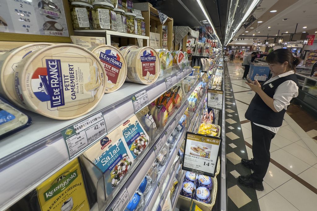 Pegawai supermarket memeriksa produk turunan susu yang diimpor dari Eropa di sebuah supermarket di Beijing, China, Rabu (21/8/204). 