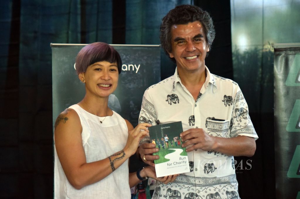 Pelari Carla Felany bersama Direktur Nasional SOS Children’s Village Greg Hadi Nitihardjo saat acara peluncuran buku pertama Carla berjudul <i>Run for Charity, Menemukan Diri dengan Berlari</i> di salah satu kafe di pusat perbelanjaan Jakarta Pusat, Minggu (10/7/2022). 