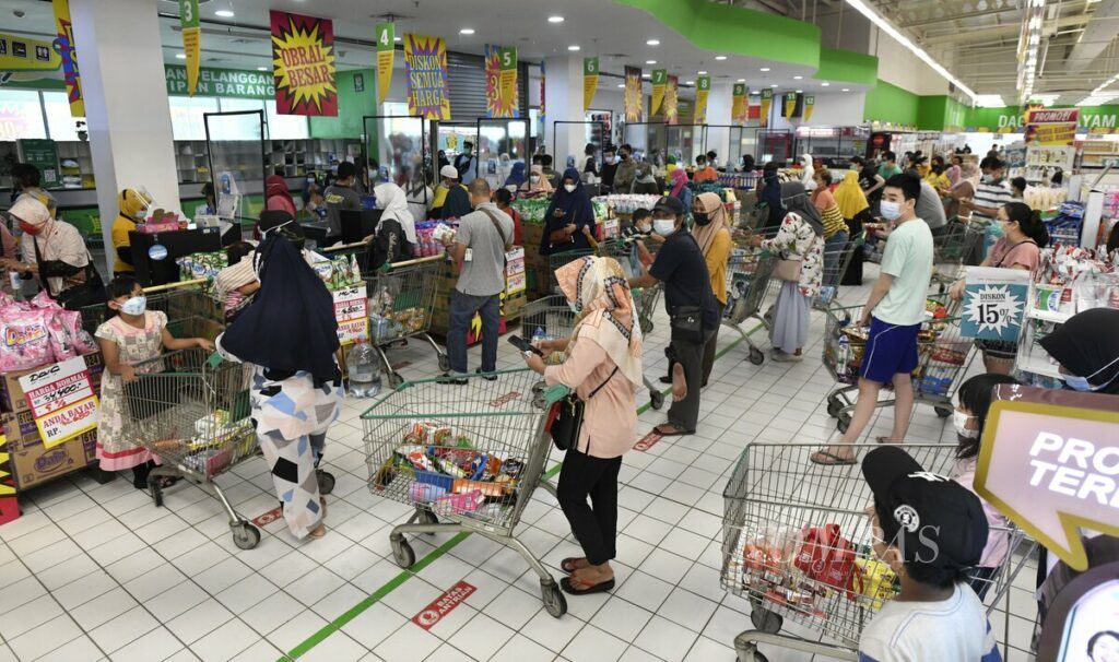 Antrean pengunjung yang akan membayar barang belanja di kasir gerai hipermarket Giant Ekstra Alam Sutera, Tangerang Selatan, Minggu (30/5/2021). Pengunjung menyerbu sejumlah gerai Giant untuk berbelanja barang yang ditawarkan dengan harga diskon.