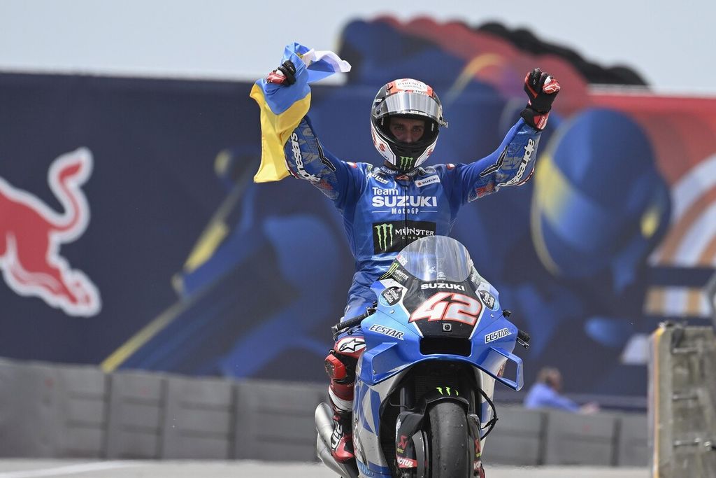Pebalap tim Suzuki, Alex Rins, merayakan keberhasilannya merebut podium kedua dengan putaran kemenangan sambil membawa bendera Ukraina dan menyerukan perdamaian pada MotoGP seri Amerika Serikat di Sirkuit Amerika, Austin, Texas, AS, Minggu (10/4/2022).