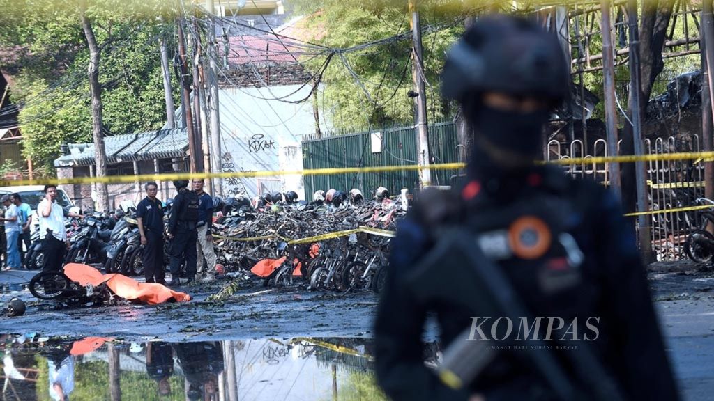 Petugas Brimob Polda Jawa Timur berjaga di lokasi meledaknya bom di Gereja Pantekosta Pusat Surabaya di Jalan Arjuno, Surabaya, Minggu (13/5/2018).