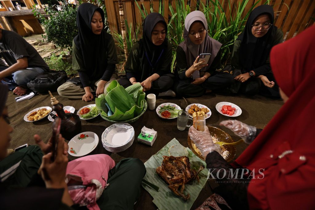 Peserta makan bersama masyarakat dengan makanan khas Desa Kemiren dalam acara Festival Kemiren 2023 di Desa Kemiren, Kabupaten Banyuwangi, Jawa Timur, Jumat (17/11/2023).