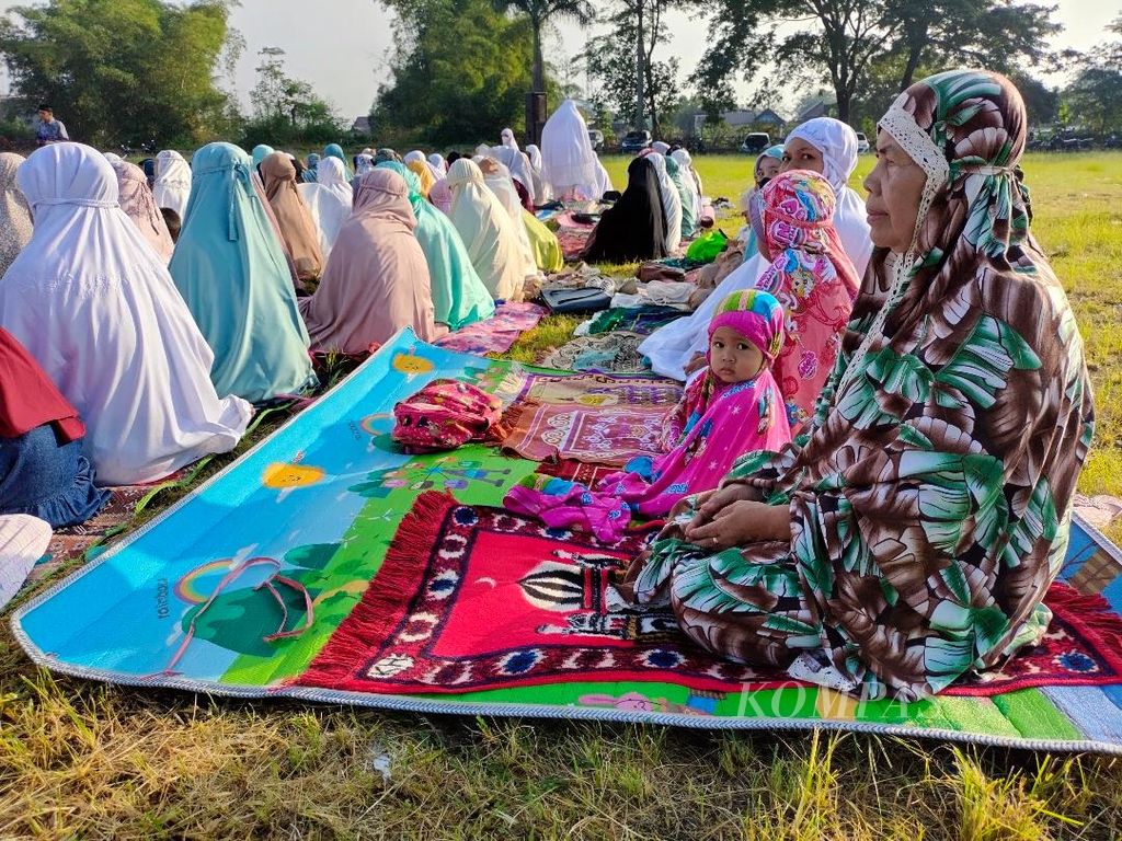 Seorang nenek ditemani cucunya mengikuti shalat Idul Fitri di Lapangan Nambangan, Kecamatan Magelang Tengah, Kota Magelang, Jumat (21/4/2023).